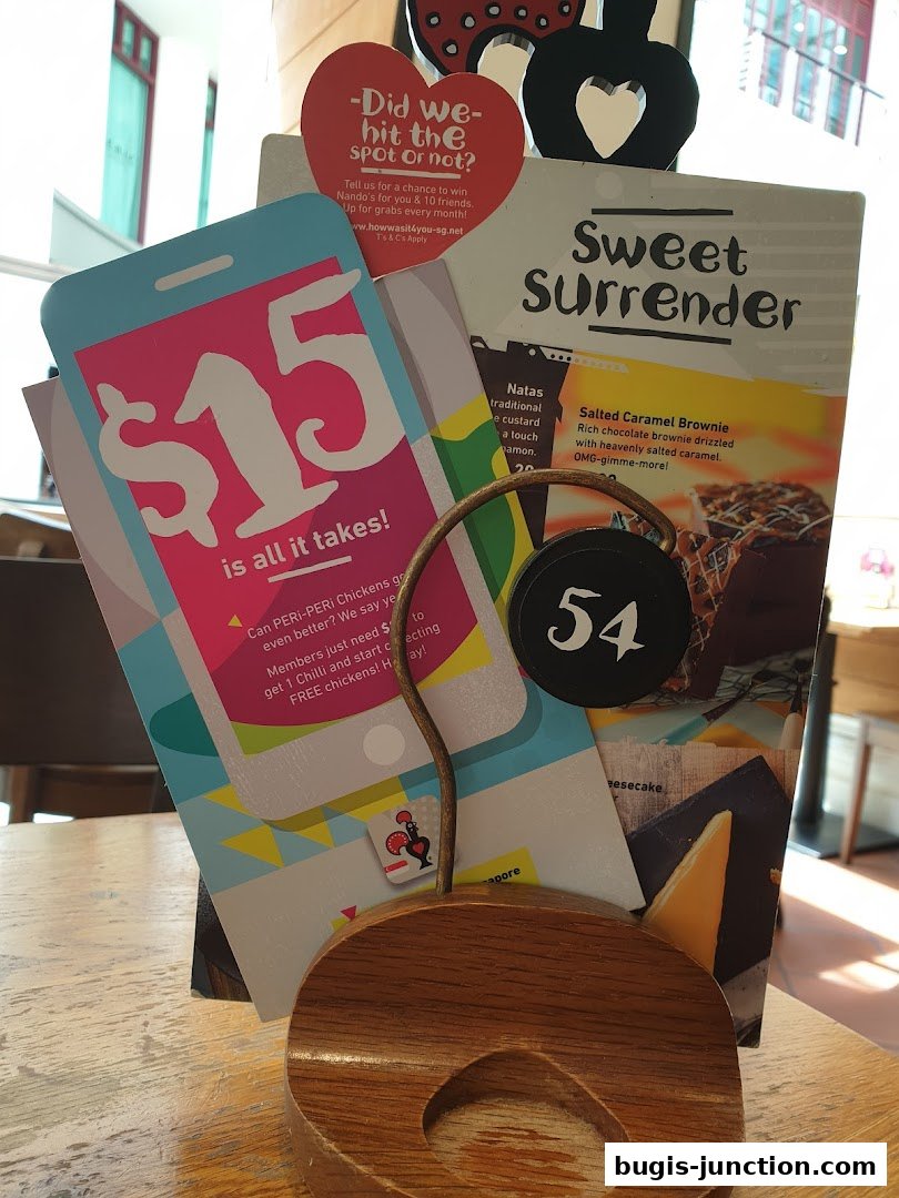 A table display at Nando's featuring promotional flyers and a table number.