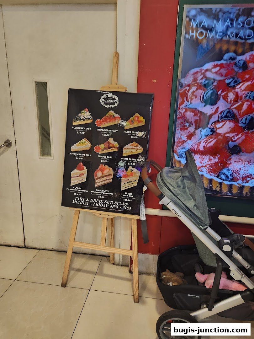 A menu board displays various tarts and cakes from MA MAISON, with a promotional set offer.