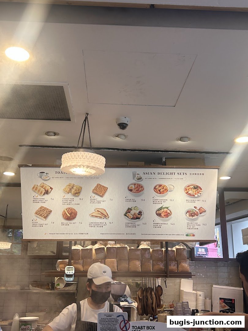 A menu board displaying various Asian delight sets and toast sets at Toast Box.