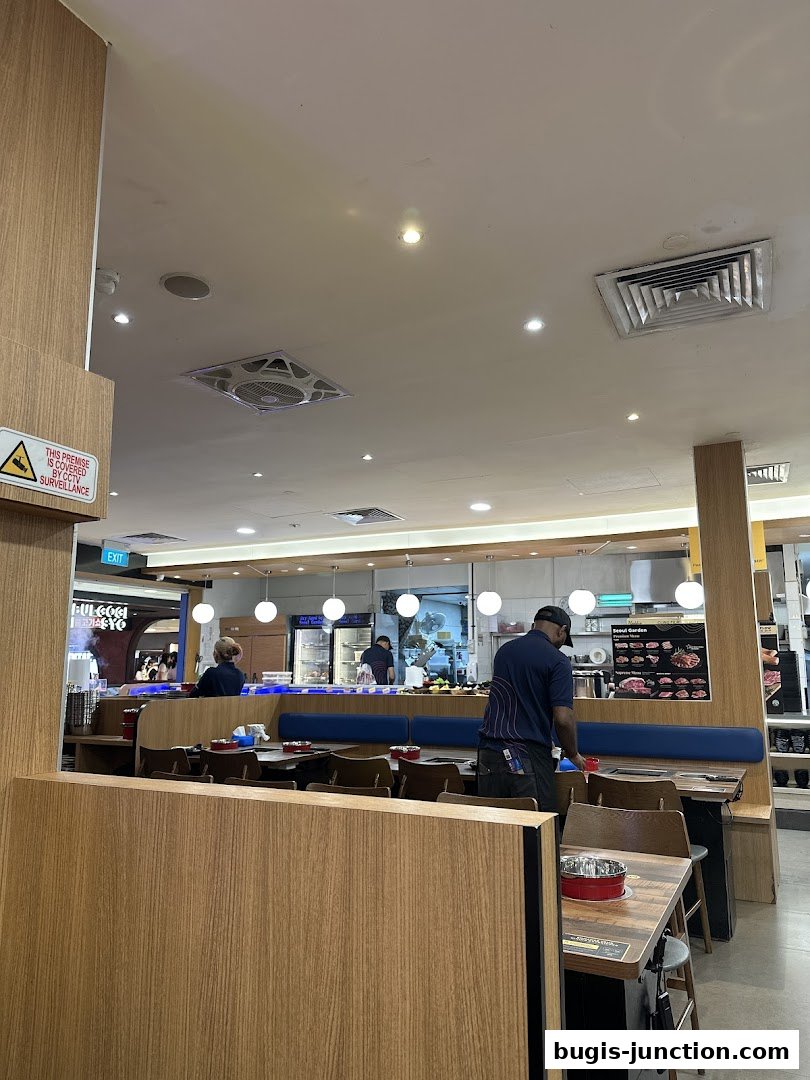 Interior view of Seoul Garden restaurant with tables set for dining and staff attending to customers.