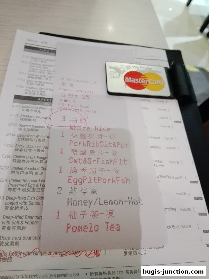 A close-up of a restaurant bill showing various dishes and a Mastercard.