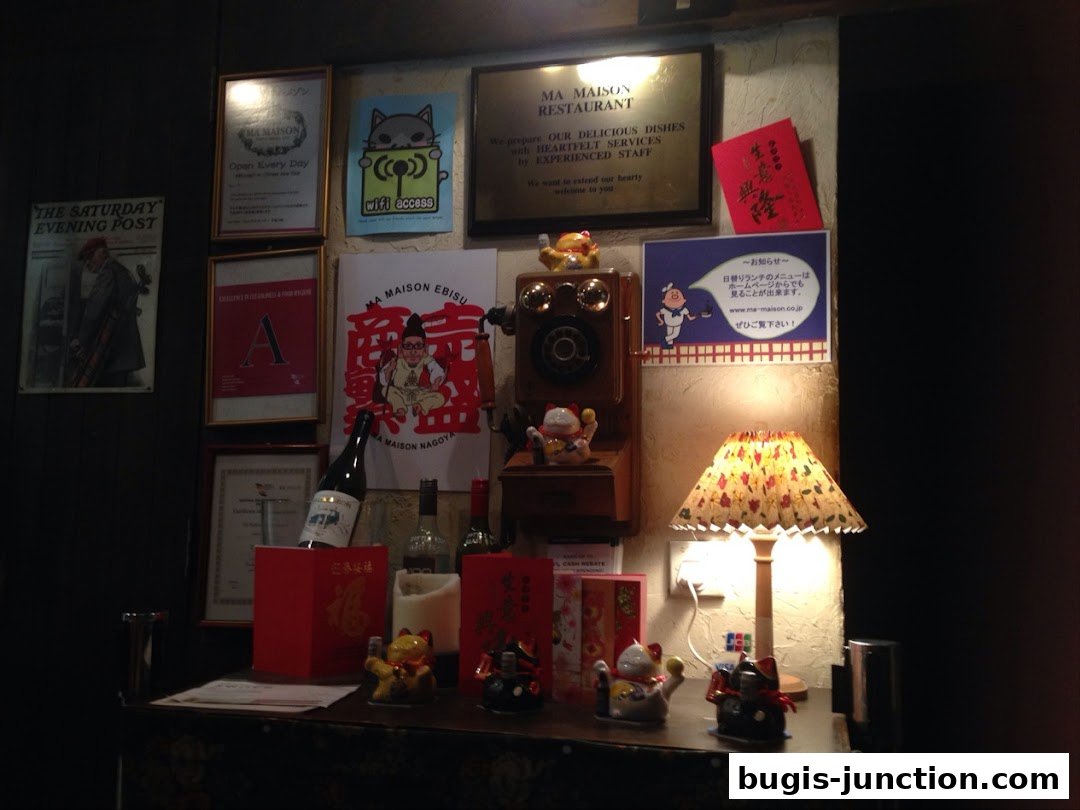 A wall display in a restaurant with framed posters, a vintage phone, and decorative items.