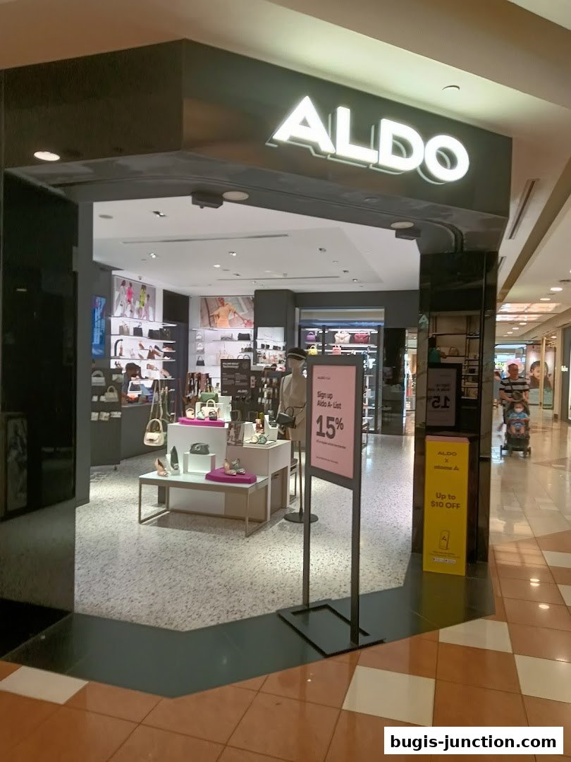 The entrance to an ALDO store showcasing shoes and handbags, with promotional signs.