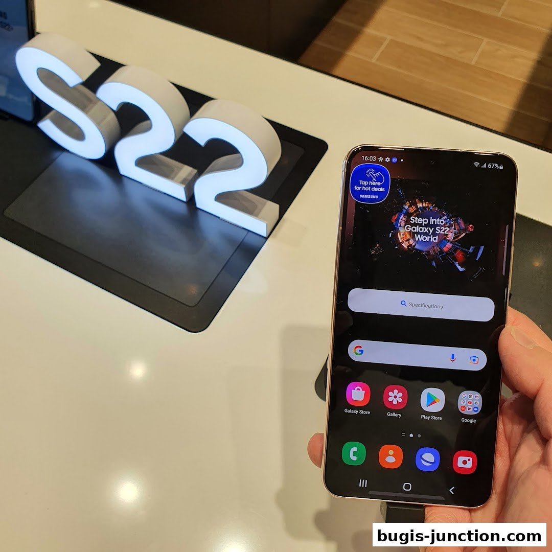 A Samsung Galaxy S22 phone is displayed next to illuminated S22 signage.