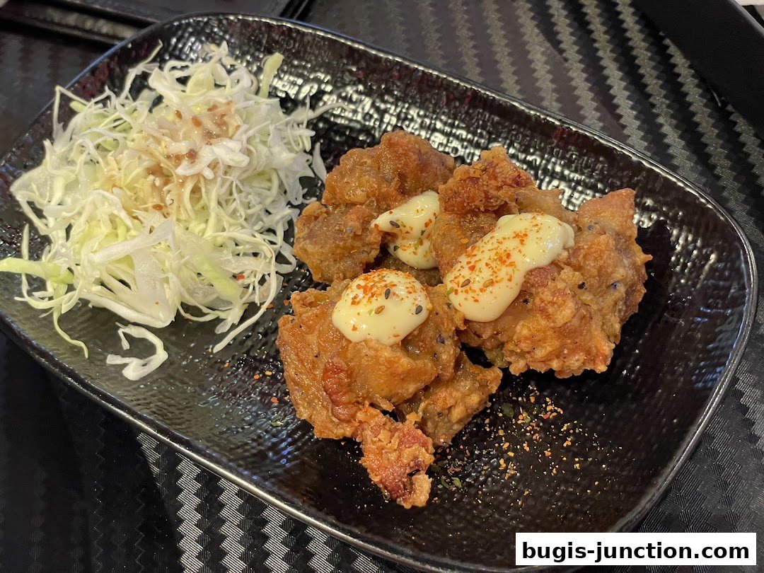 A plate of crispy fried chicken with mayonnaise and a side of shredded cabbage salad.