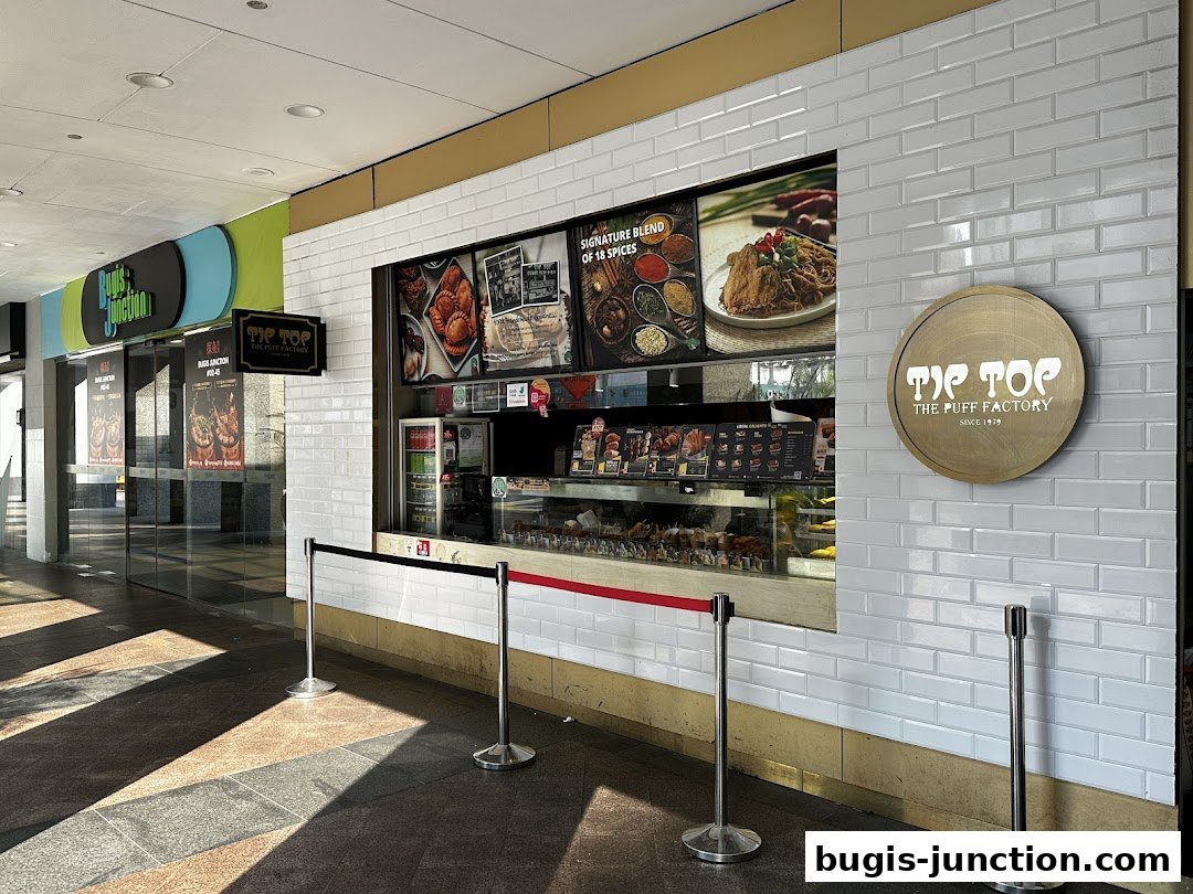 The exterior of Tip Top Curry Puff at Bugis Junction, showcasing its food display and signage.