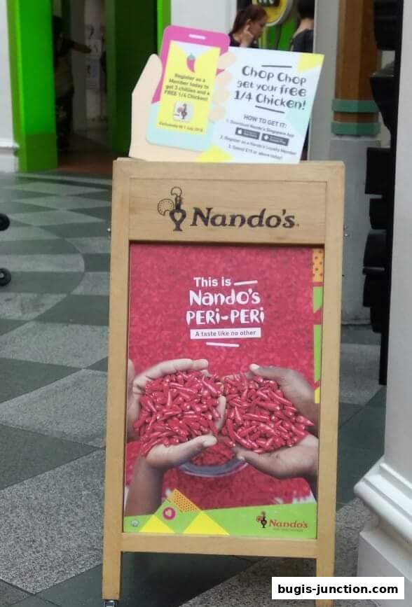 A Nando's A-frame sign advertising a free 1/4 chicken with a promotion.