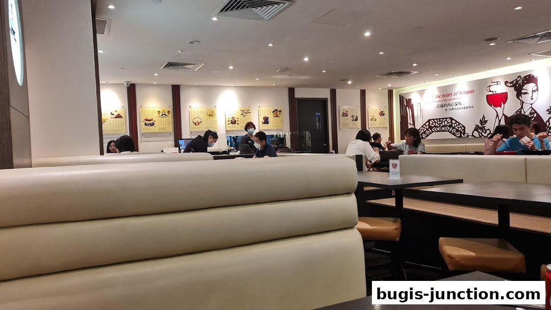 Interior of a restaurant with diners seated at booths and tables, some staff visible.