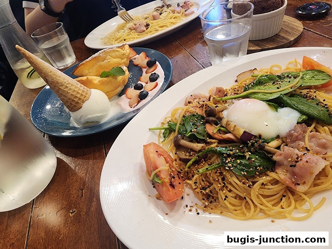 A table laden with delicious pasta dishes and a dessert with ice cream and berries.
