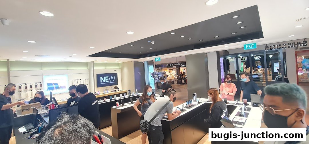 Customers browse the latest Samsung products in a brightly lit store with staff assistance.