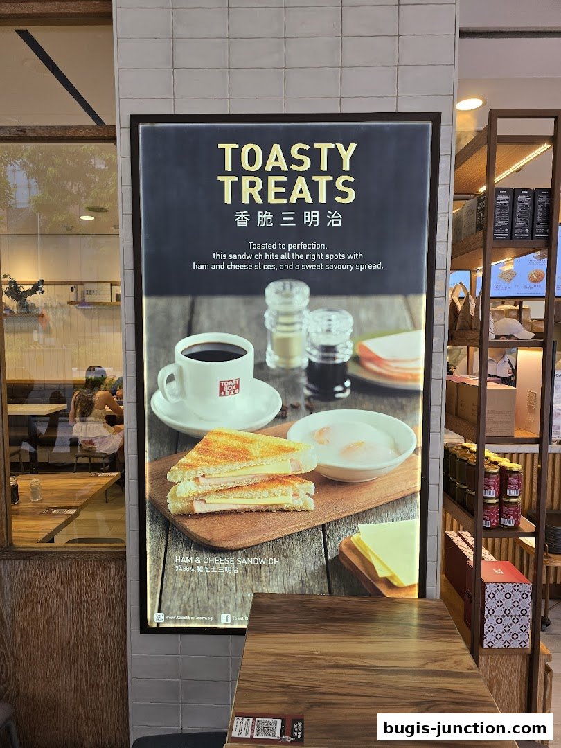 A sign advertising a Ham & Cheese Sandwich with coffee and soft-boiled eggs.
