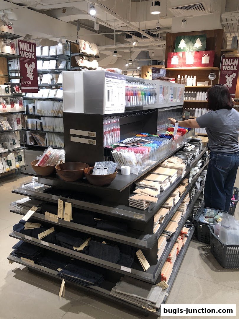 Interior view of a MUJI store showcasing stationery, bags, and home goods.