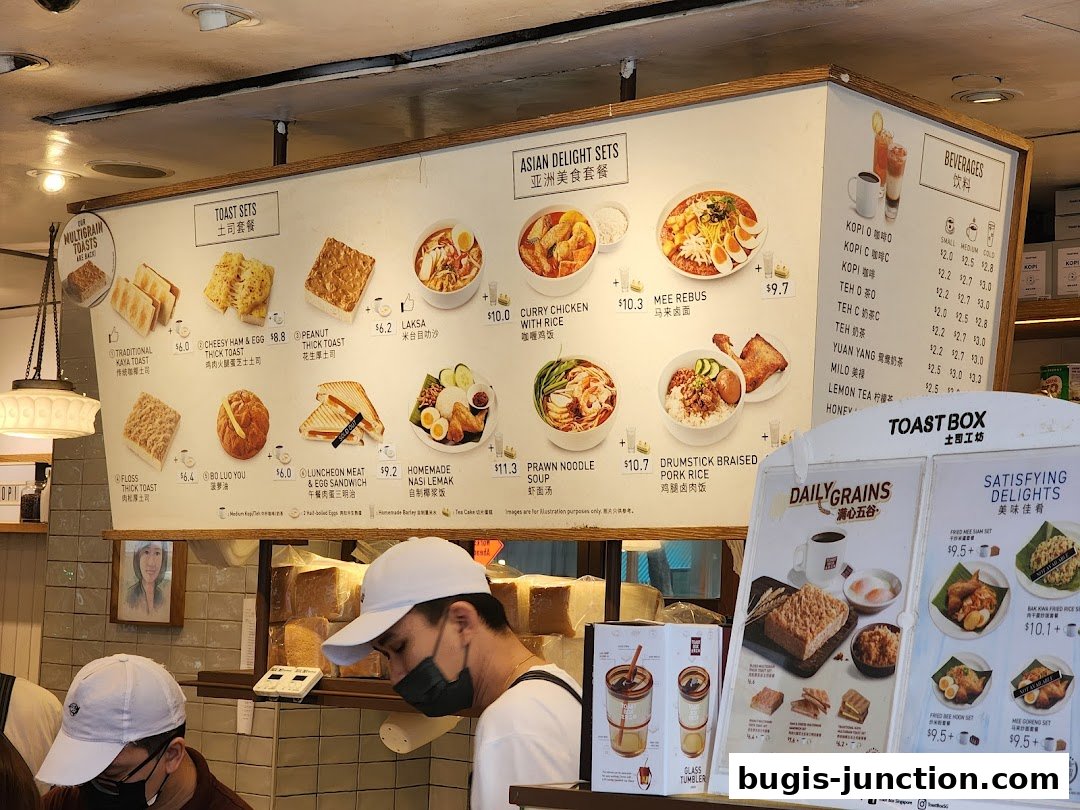 A menu board displaying various toast sets, Asian delights, and beverages at Toast Box.