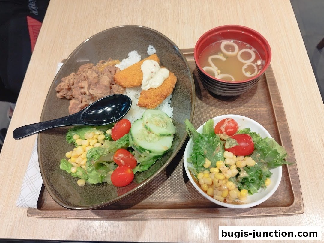 A Yoshinoya meal featuring rice, beef, fried fish, salad, and soup.