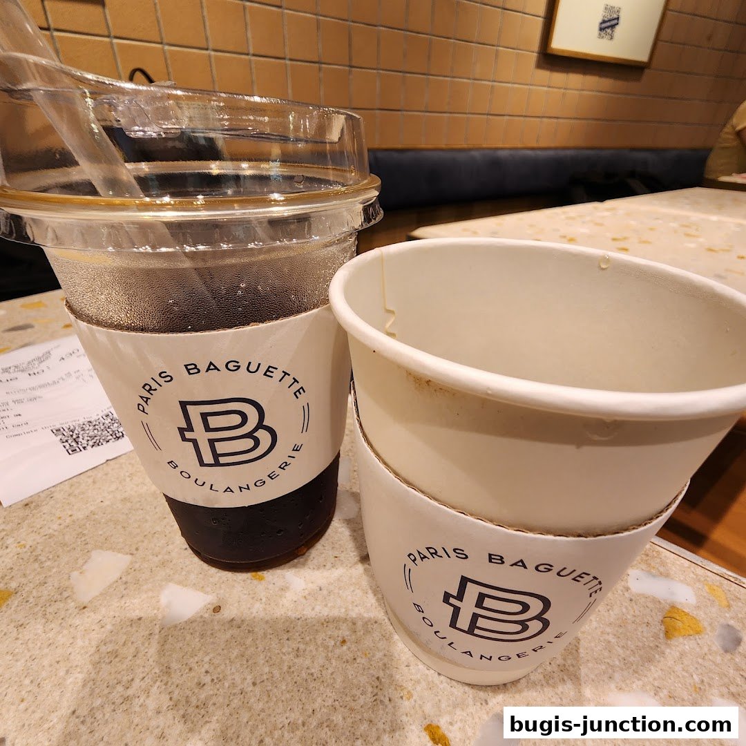 Two cups with Paris Baguette branding on a speckled table, with a receipt nearby.