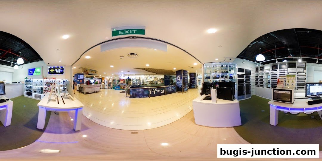 Interior view of a modern electronics store showcasing laptops, computers, and accessories on display.