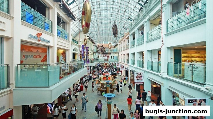 A bustling multi-level shopping mall interior with various shops and shoppers.