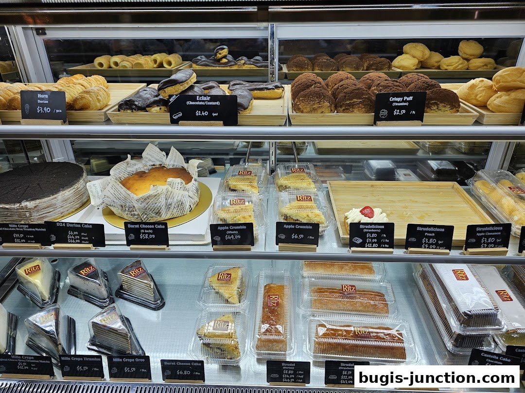 A display case filled with various cakes, pastries, and strudels from Ritz Apple Strudel.
