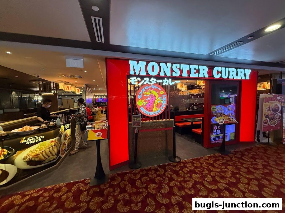 The entrance of Monster Curry restaurant with its bright red facade and prominent signage.