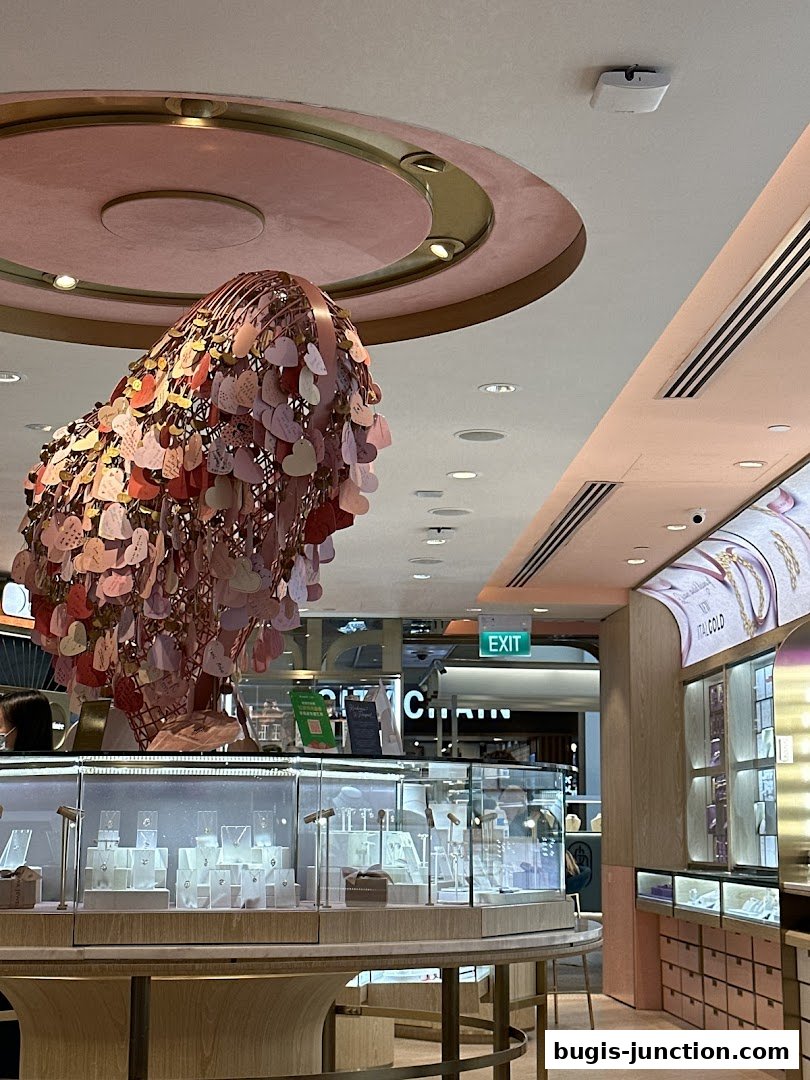 Interior of a jewelry store with display cases and a decorative heart sculpture.