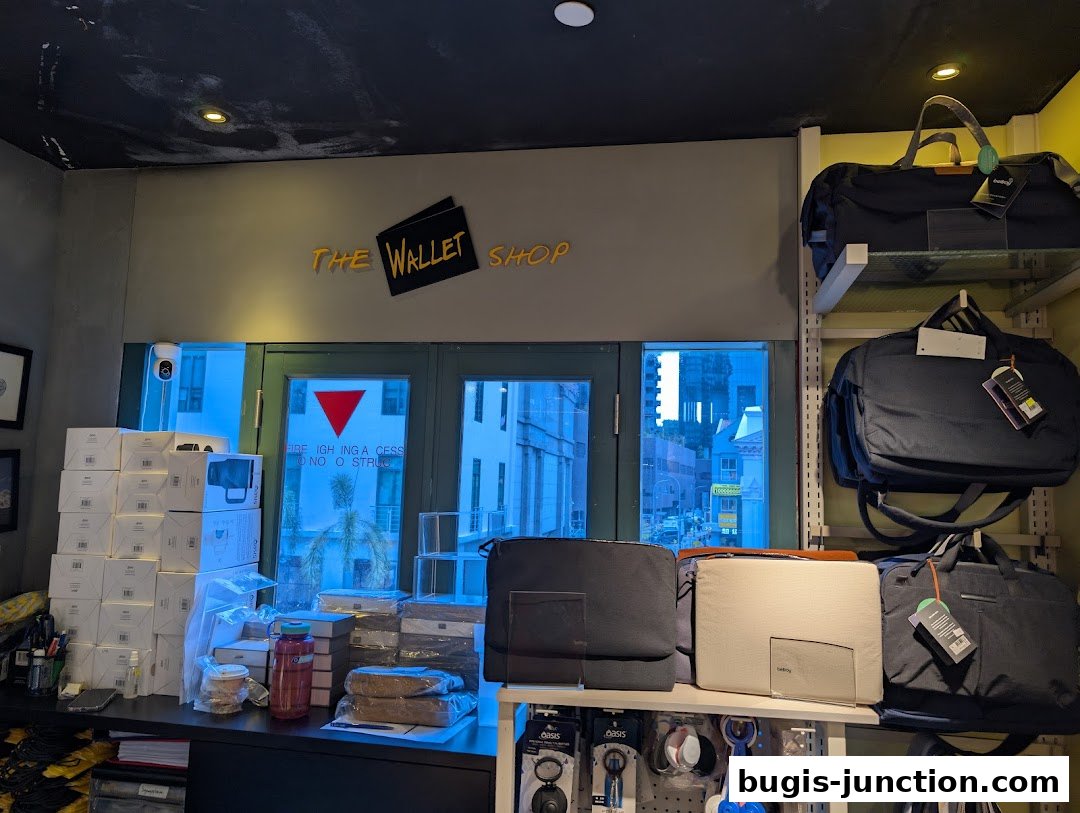 Interior view of The Wallet Shop showcasing various bags and accessories on shelves and a counter.