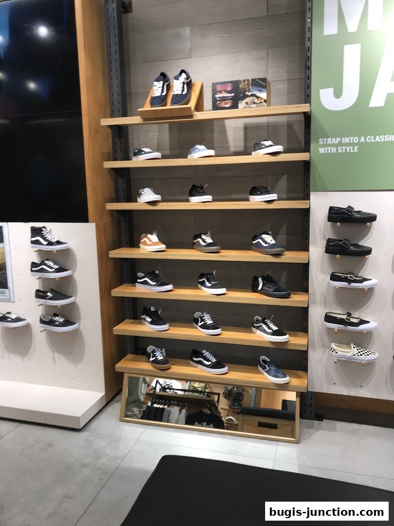A display of various Vans shoes on shelves in a retail store.