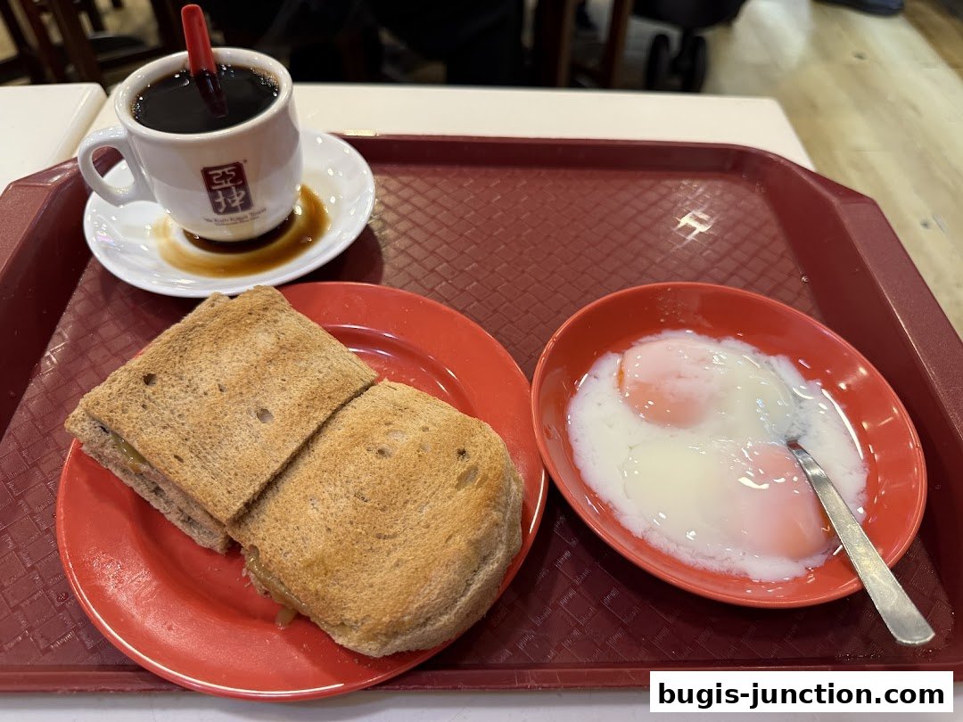 A tray with Ya Kun Kaya Toast's signature kaya toast, soft-boiled eggs, and coffee.