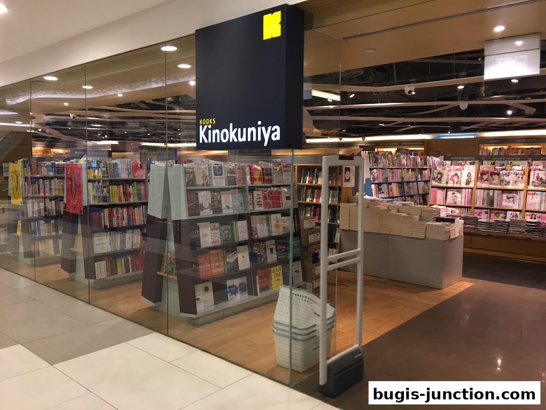 The entrance and interior of a large bookstore, Books Kinokuniya, filled with shelves of books.