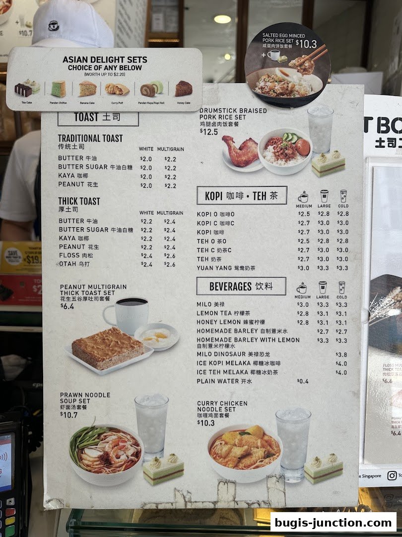 A menu board displaying various Asian delight sets, toasts, beverages, and noodle sets from Toast Box.