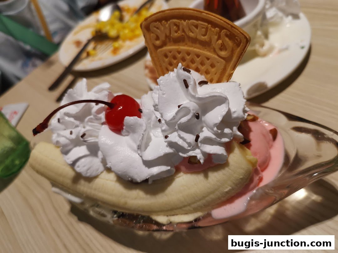 A delicious banana split dessert with whipped cream, cherry, and a Swensen's waffle.