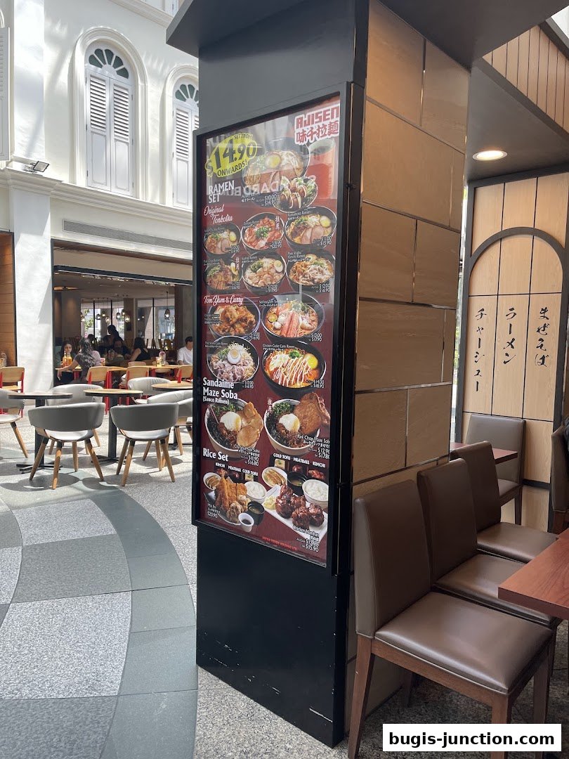 A display board showcasing various ramen and rice sets from Ajisen Ramen.
