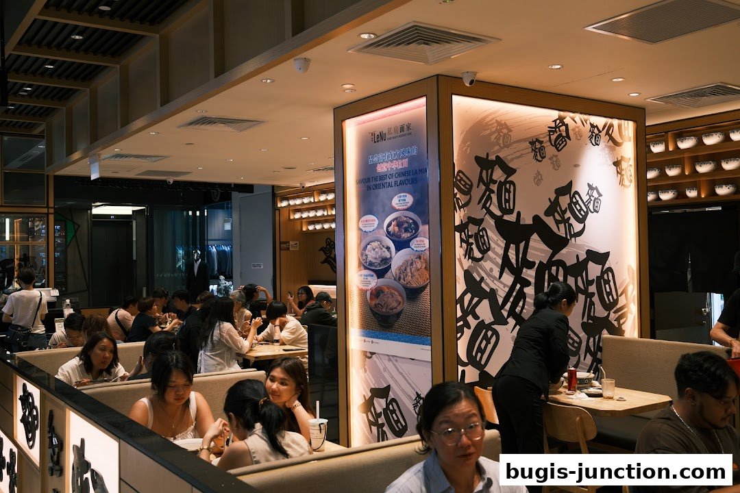 Interior of a busy noodle bar with customers dining and staff serving.