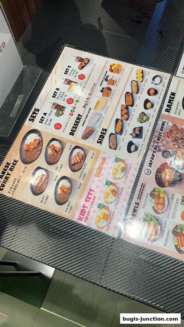 A menu from Yoshinoya featuring Japanese curry rice, sets, sides, desserts, kids' meals, and bowls.
