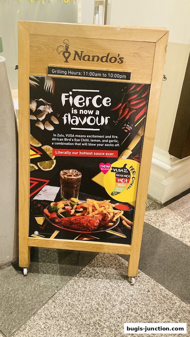 A Nando's A-frame sign advertising their 'Fierce flavour' with a meal and sauce options.