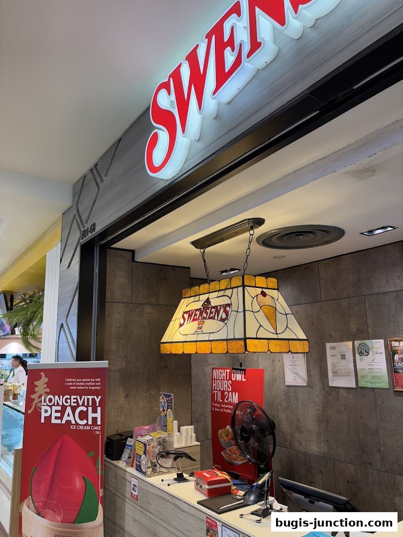 The entrance of Swensen's Bugis Junction, featuring the shop's sign and a promotional poster.