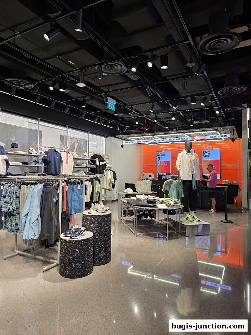 Interior view of a modern Nike store showcasing apparel, footwear, and displays.
