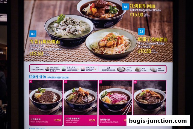 A menu board displaying various noodle dishes with prices and descriptions.