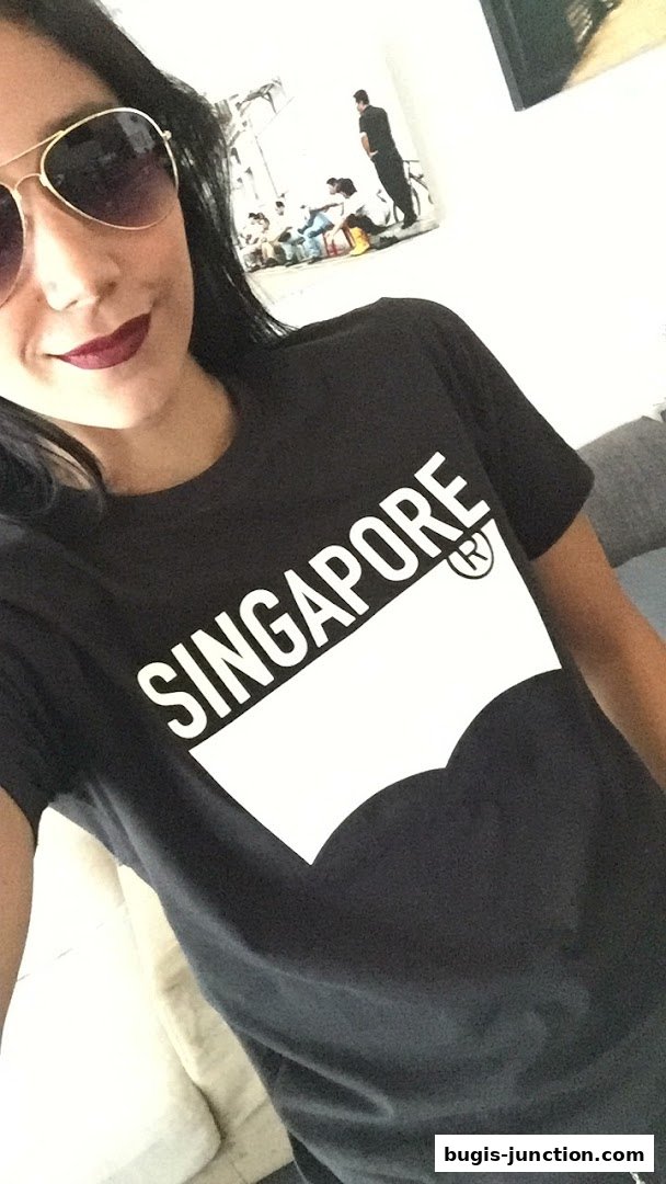 A woman wearing a black t-shirt with 'SINGAPORE' and the Levi's logo.