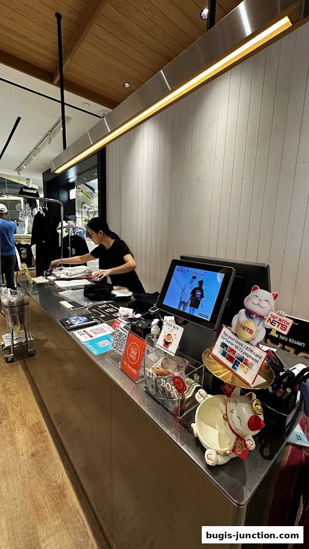 A cashier at RECOIL shop is processing a transaction at the counter.