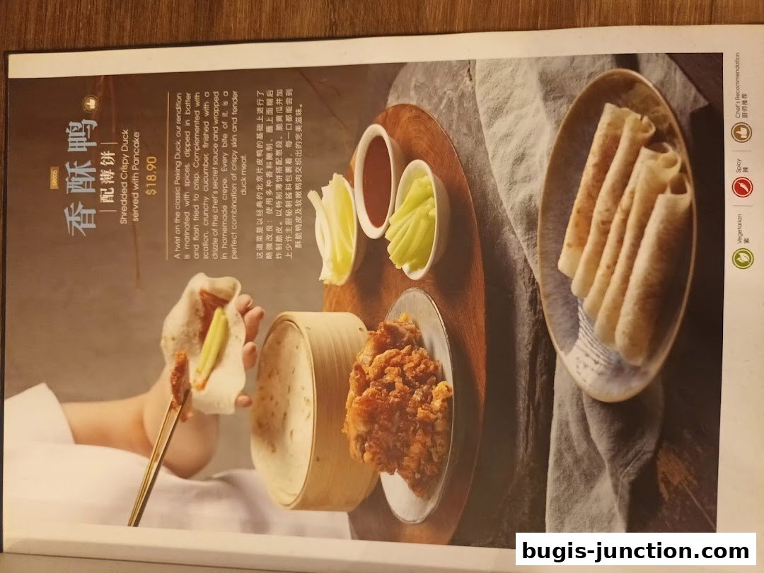A menu item featuring shredded crispy duck served with pancakes and accompaniments.