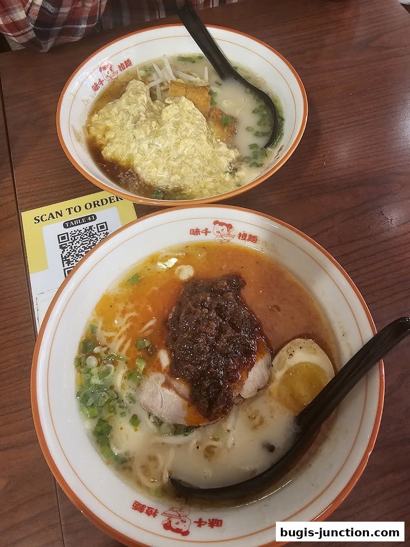 Two bowls of delicious ramen, one with scrambled egg topping, on a wooden table.
