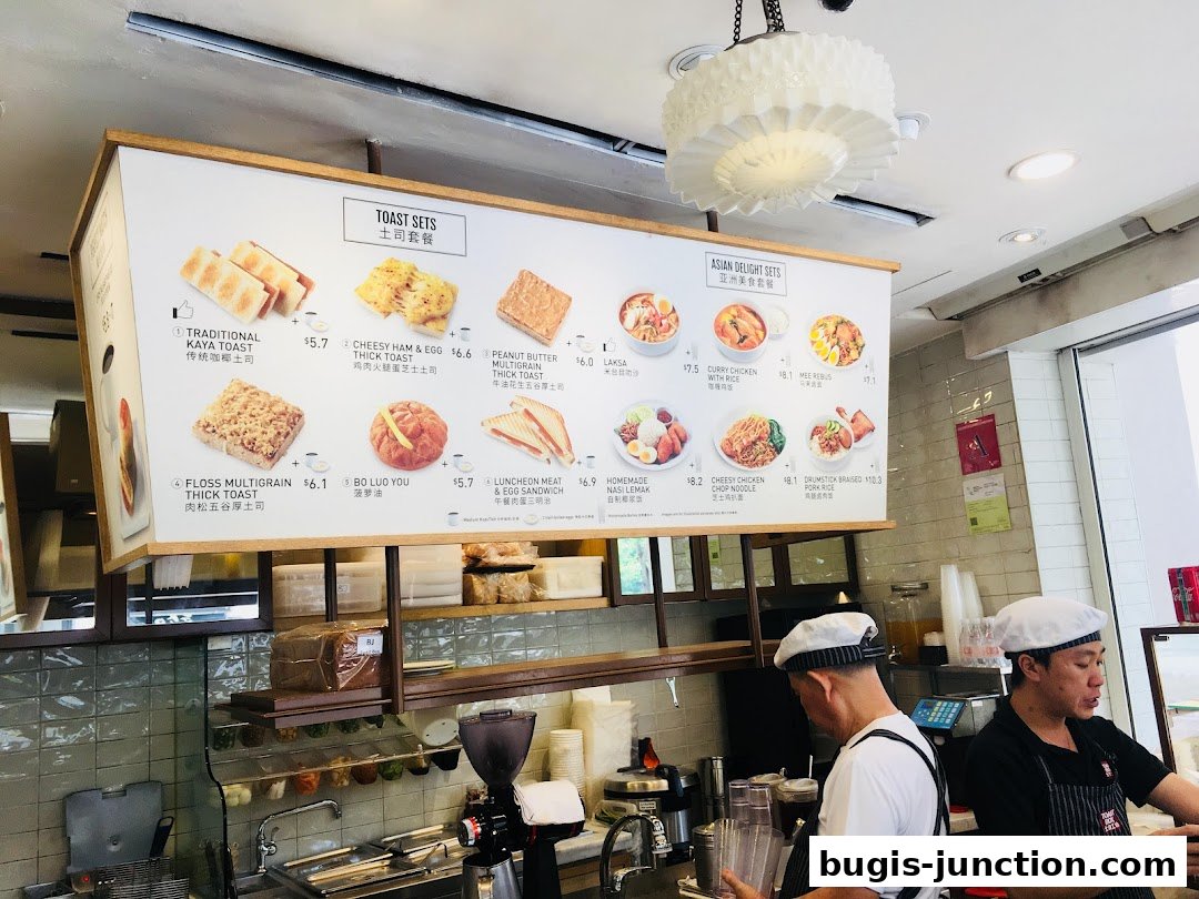 A menu board displaying various toast sets and Asian delights with prices and images.