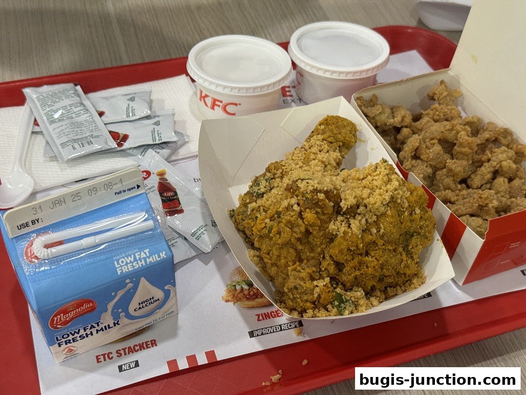 A tray of KFC fried chicken, milk, and condiments on a red tray.