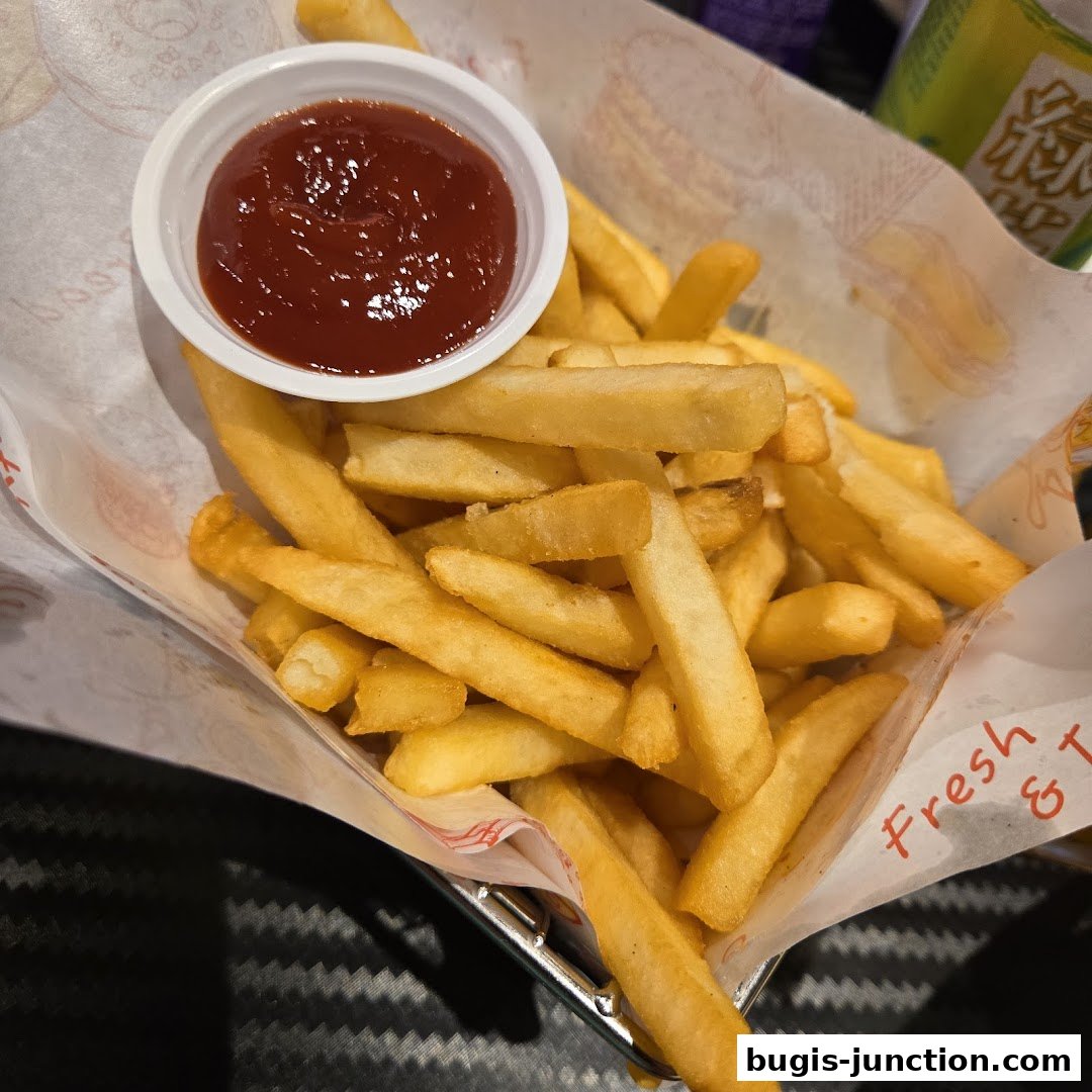 A basket of golden french fries served with a side of ketchup.