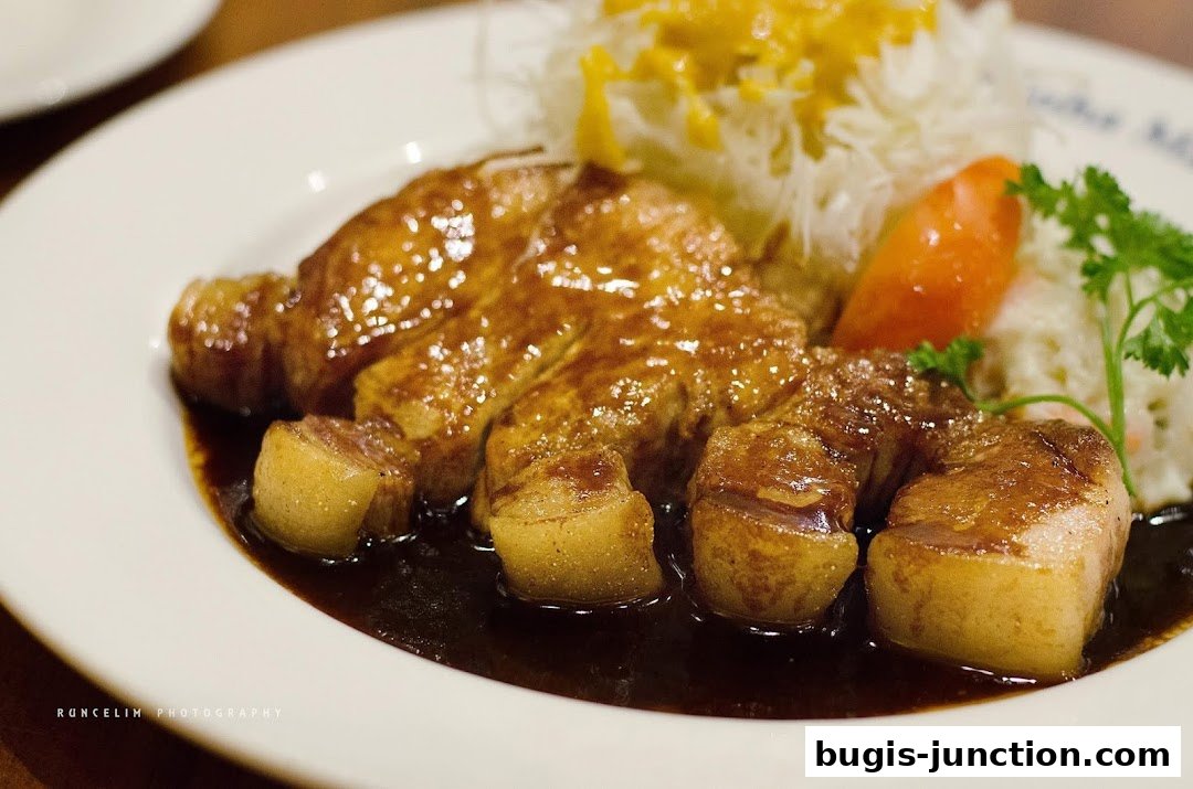 A close-up shot of a delicious dish with glazed meat, shredded cabbage, and a carrot.
