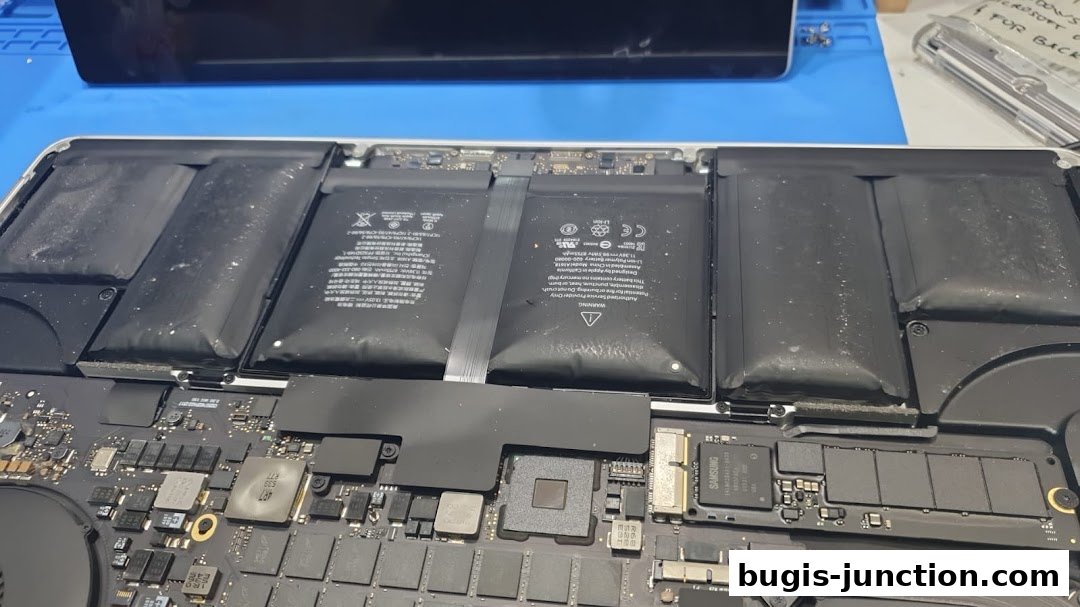 Close-up view of a disassembled laptop, showing internal components like batteries and circuit boards.