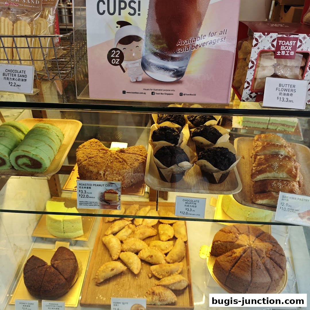 A display case filled with various pastries, cakes, and cookies from Toast Box.