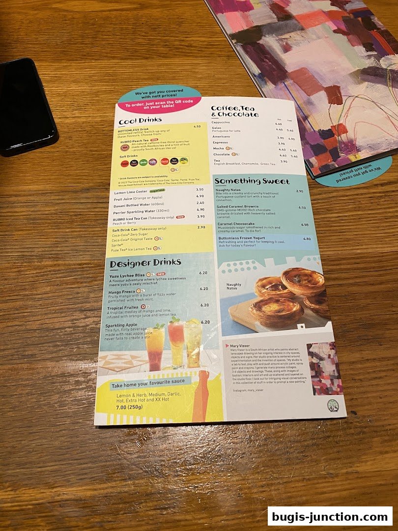 A menu from Nandos featuring drinks, desserts, and sauces, with a QR code for ordering.