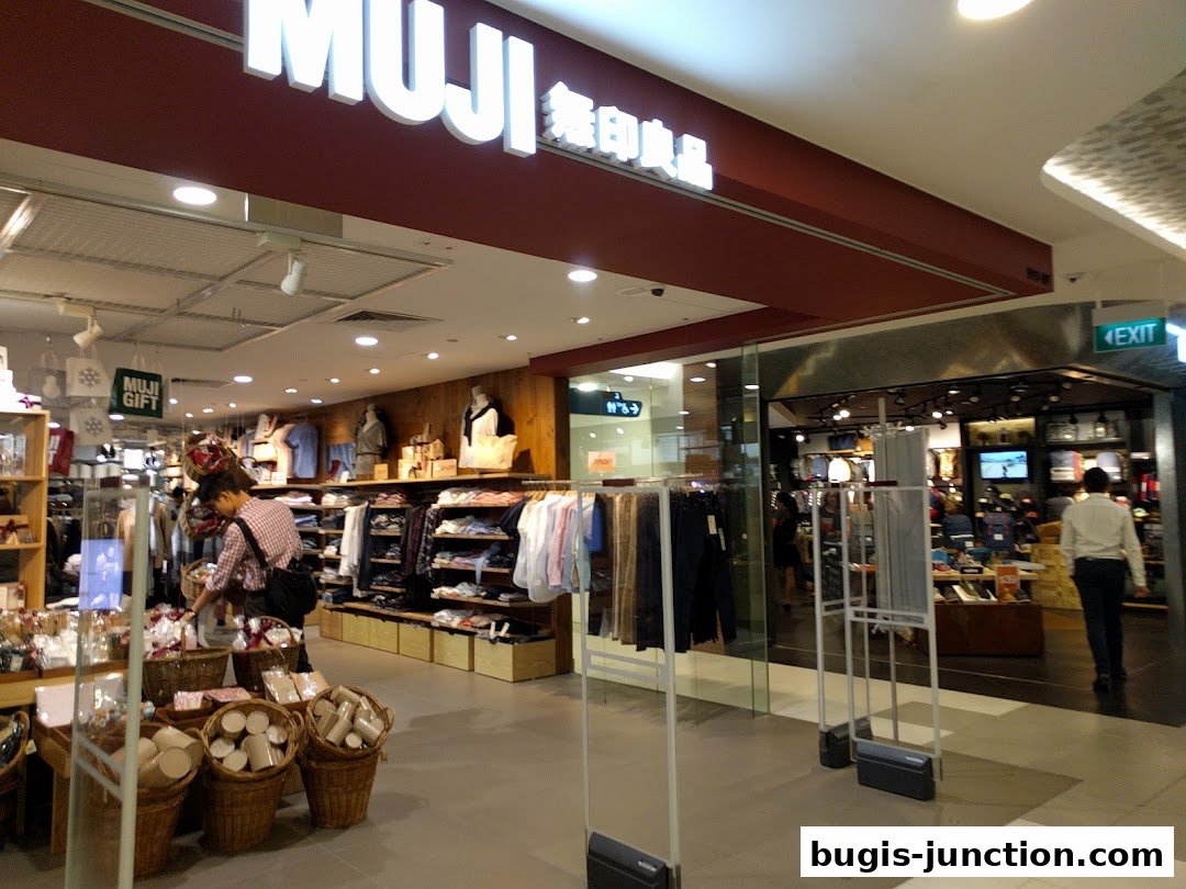 Interior view of a MUJI store showcasing clothing, gifts, and home goods.