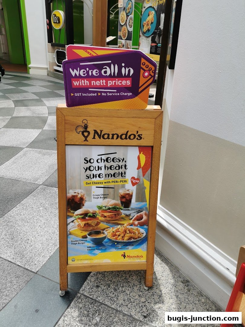 A Nando's A-frame sign advertising cheesy PERi-PERi burgers and loaded chips.